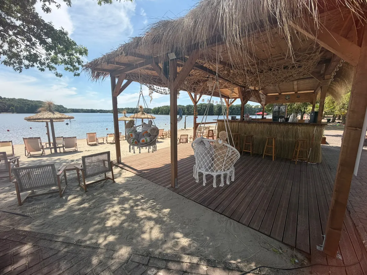 Strandbar mit Strohdach im Beach Club mit Blick auf den Wolfssee