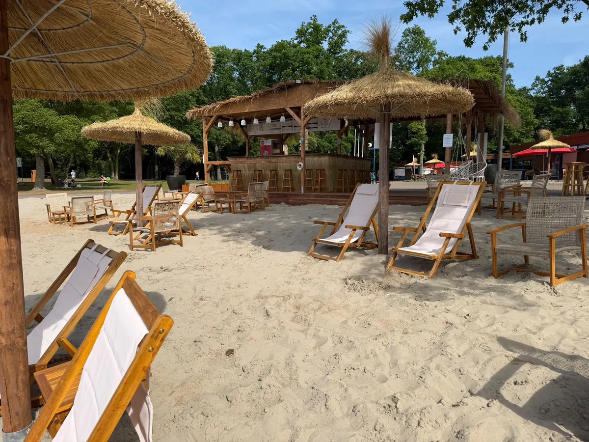Liegestühle im Sand vor der Strandbar