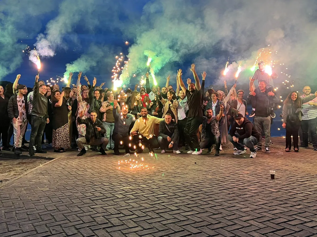 Gruppenfoto mit Wunderkerzen bei einer Feier auf der Beacharea
