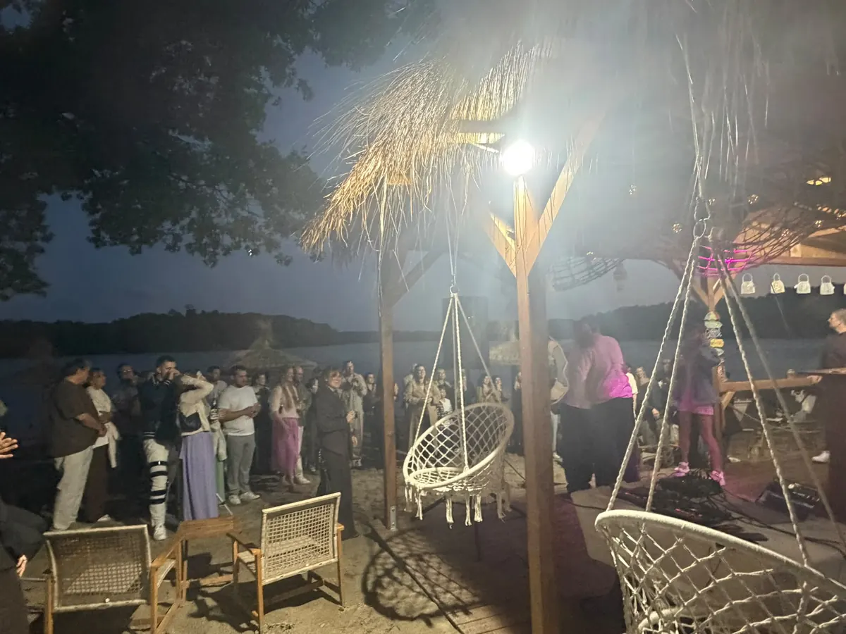Feier am Abend mit Hängesesseln unter dem Strohdach