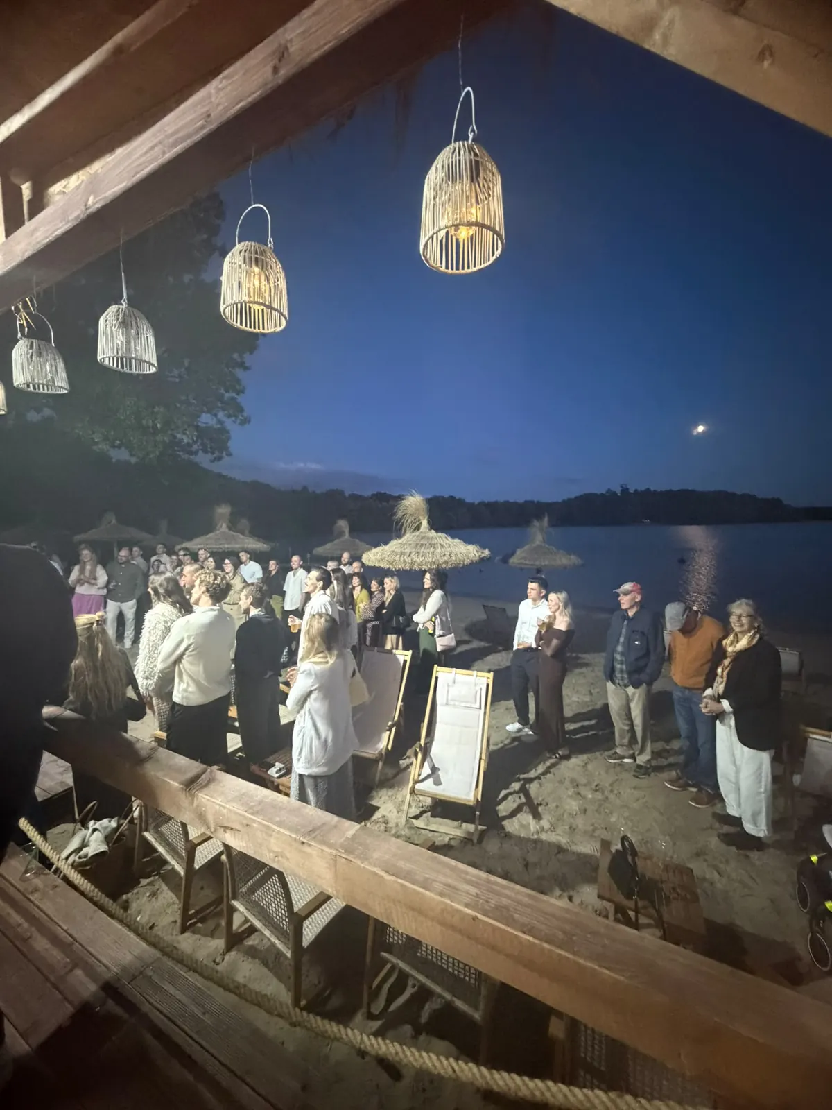 Abendveranstaltung mit Gästen am Strand des Wolfssees