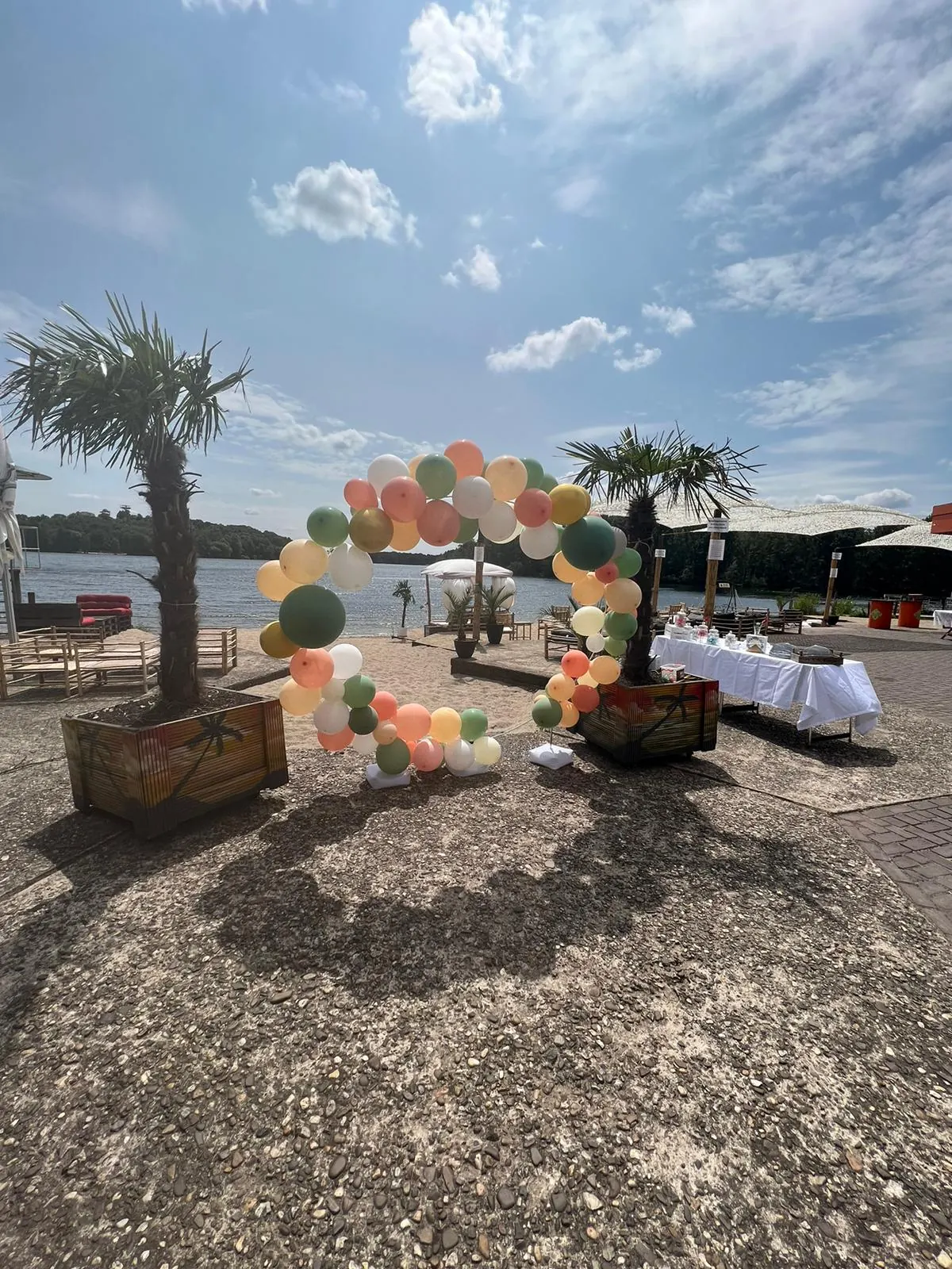 Mit Ballons und Palmen dekorierte Beacharea für eine Feier